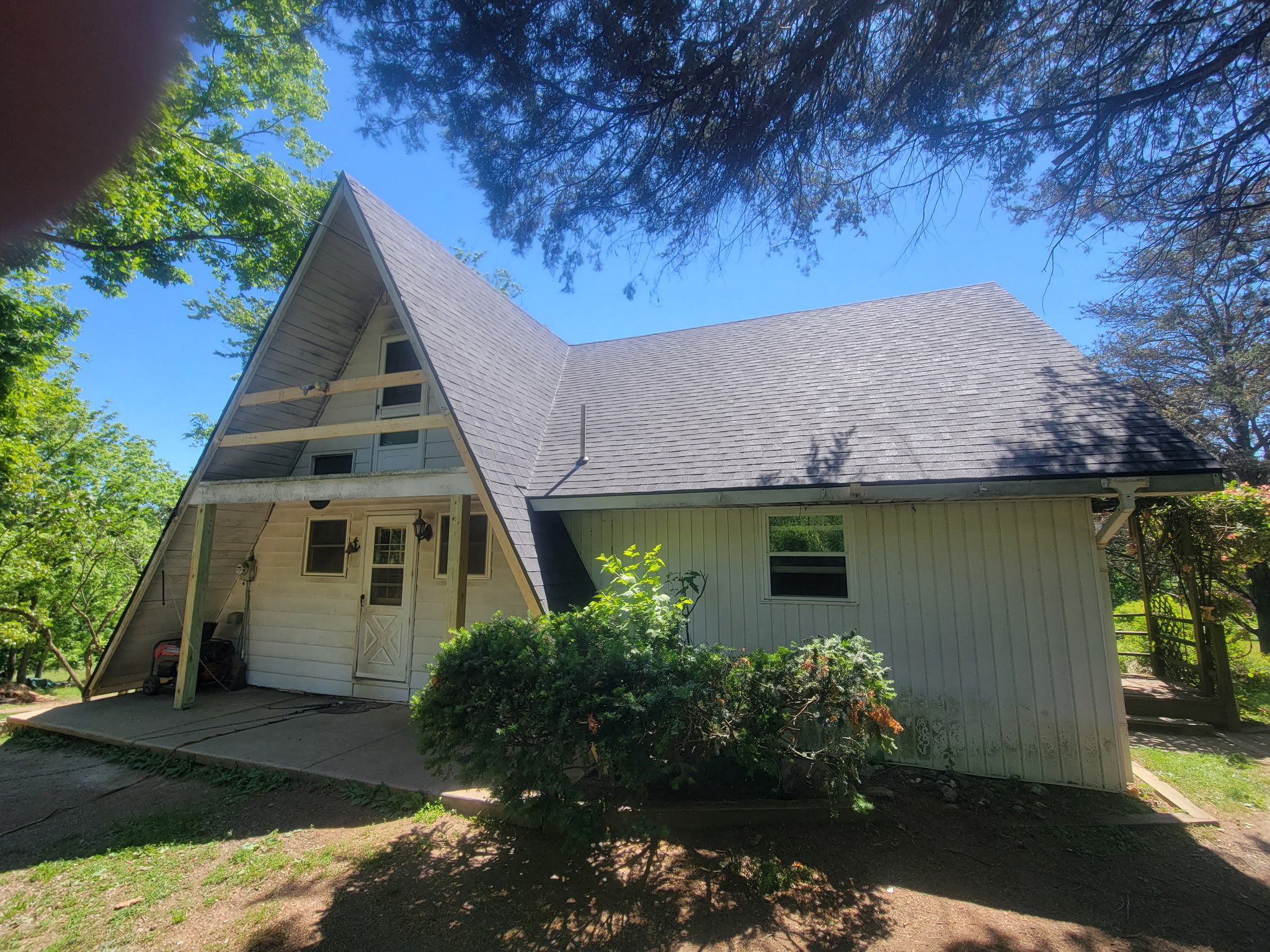 The front of an A-frame home with an addition.